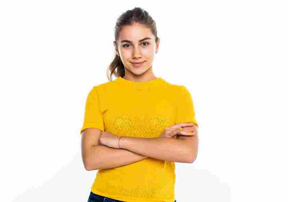 A person in a yellow shirt stands with arms crossed against a white background